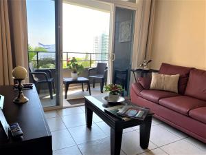 a living room with a red couch and a balcony at Luxury Modrn Apartment, w/amazing view, 3BR,Escalon,Exclus,Secur in San Salvador