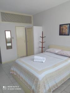 1 dormitorio con 1 cama grande y 2 toallas. en Hotel Minas Salvador, en Salvador