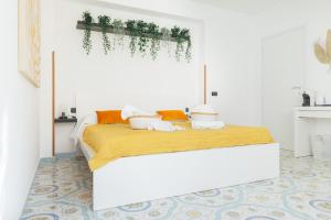 a white bedroom with a bed in a room at Archi Bianchi in Cefalù