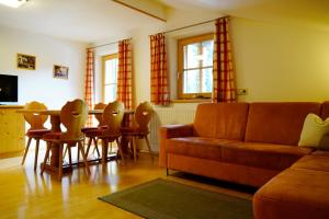 a living room with a couch and a table and chairs at Lederer Zuhaus in Alpbach