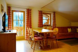 ein Wohnzimmer mit einem Tisch, Stühlen und einem Sofa in der Unterkunft Lederer Zuhaus in Alpbach