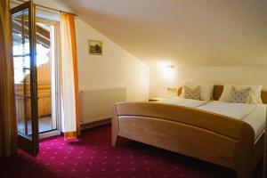 Un dormitorio con una cama grande y una ventana. en Lederer Zuhaus, en Alpbach