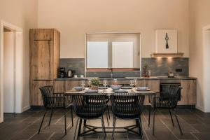 a dining room with a table and chairs in a kitchen at FRG Villas - Villa Volare in Kefallonia