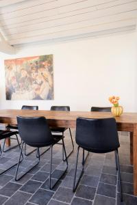 una mesa y sillas en una habitación con una pintura en Loweide Lodges & Holiday Homes near Bruges en Oostkamp
