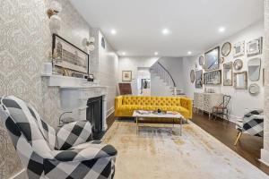 a living room with a yellow couch and a fireplace at Designer 3 BR Townhome with Beautiful Backyard in Philadelphia
