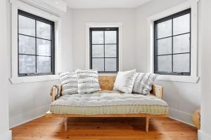 フィラデルフィアにあるDesigner 3 BR Townhome with Beautiful Backyardの窓3つ付きの部屋にソファが備わります。