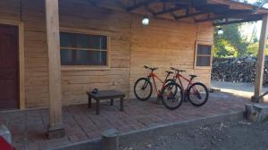 two bikes parked in front of a wooden cabin at HABITACIÓNES PRIVADAS EN HERMOSA CASA DE CAMPO MALLOA in Malloa