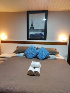 1 cama con 2 toallas y la torre Eiffel en Pousada dos Pássaros en Gramado