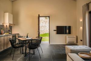 uma cozinha e sala de estar com mesa e cadeiras em FRG Villas - Villa Cantare em Cefalônia