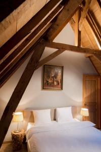 a bedroom with a white bed in a attic at Loweide Lodges & Holiday Homes near Bruges in Oostkamp