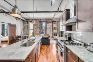 een keuken met houten vloeren en een bakstenen muur bij 30 S 7th St Unit 3 LUXURIOUS Million Dollar Condo Elevator Parking Location in Philadelphia