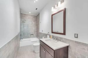 a bathroom with a sink and a toilet and a mirror at 30 S 7th St Unit 3 LUXURIOUS Million Dollar Condo Elevator Parking Location in Philadelphia