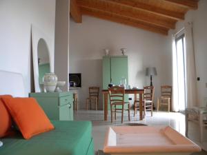 a living room with a green couch and a table at La Foresteria di Borgogelsi Apartments in Sanguinetto