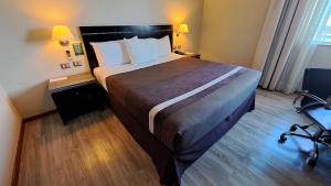 Una cama o camas en una habitación de Hotel Diego de Almagro Chillan