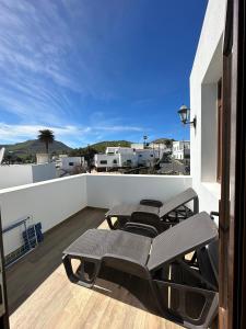 een balkon met een tafel en stoelen op een dak bij Casa Isidro in Haría