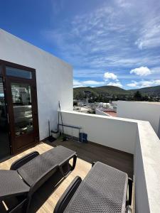 d'une terrasse avec des chaises et des tables sur un balcon. dans l'établissement Casa Isidro, à Haría