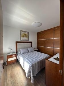 1 dormitorio con 1 cama grande y armario de madera en Casa Isidro, en Haría