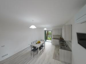 a kitchen with white cabinets and a table with chairs at Sorrento Realty Holidays - The smile of the sun in Sorrento