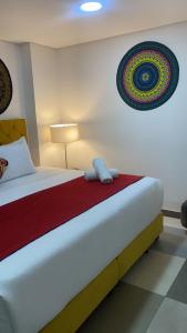 1 dormitorio con 1 cama con manta roja y blanca en Hotel Bogota Resort, en Bogotá