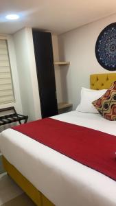 1 dormitorio con 1 cama blanca grande con manta roja en Hotel Bogota Resort, en Bogotá