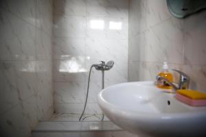 bagno bianco con lavandino e doccia di Apartment on Chubinashvili 30 a Tbilisi City