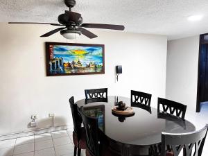 a dining room with a table and a ceiling fan at Hotel Boston Superior in Barranquilla