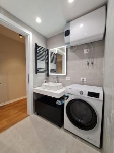 eine Waschmaschine im Bad mit Waschbecken in der Unterkunft Adore - Modern Apartment in Tirana