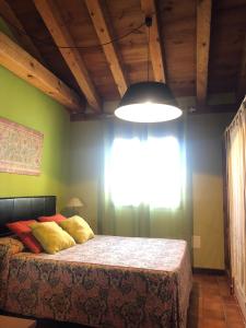 a bedroom with a bed with a window and a lamp at Apartamentos Lobiche in Navafría