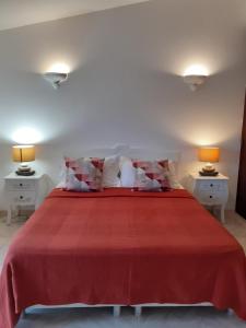 una camera con letto rosso e 2 comodini di Casa Verde ad Aljezur