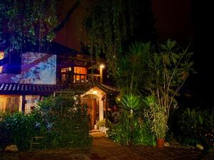 una casa de noche con muchas plantas en Casa Magnolia, en Cumbayá