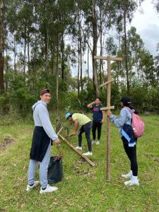 eine Gruppe von Menschen, die um ein Holzschild stehen in der Unterkunft Cabaña San Andres in Otavalo