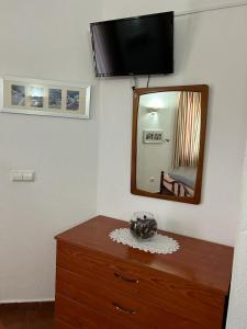 a room with a dresser with a mirror and a wooden dresser at Copacabana Residencial in Costa da Caparica