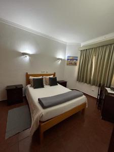 ein Schlafzimmer mit einem großen Bett in einem Zimmer in der Unterkunft Copacabana Residencial in Costa da Caparica