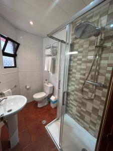 a bathroom with a shower and a toilet and a sink at Copacabana Residencial in Costa da Caparica