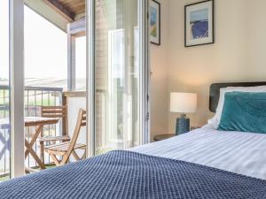 a bedroom with a bed and a balcony at 10 Oceans Edge in Kingsbridge +25 photos