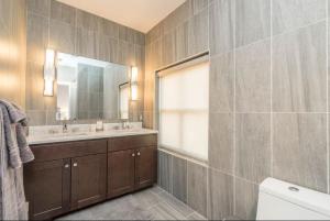 y baño con lavabo, espejo y aseo. en PRISTINE 3 BR Million-Dollar Loft Elevator Parking, en Filadelfia