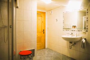 baño con lavabo y taburete rojo en Lederer Zuhaus, en Alpbach 20 fotos más