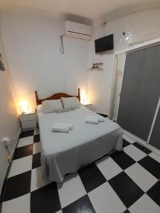 a bedroom with a bed and a checkered floor at Pensión Hidalgo 2 in Utrera