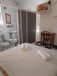 ein Bad mit einem Bett mit Handtüchern darauf in der Unterkunft Pensión Hidalgo 2 in Utrera