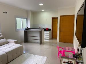 uma sala de estar com um sofá branco e uma cozinha em Loft central Sant Helena Gramado Rs em Gramado