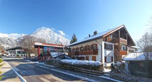 a building on a street with mountains in the background at 'Chalet-Style' ruhige & zentrale 3-Raum-Suite direkt am Kurpark in Oberstdorf