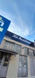 a building with a blue sign on the side of it at Pousada Kit Residence in Brasilia