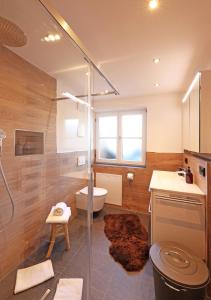e bagno con doccia, servizi igienici e lavandino. di 'Chalet-Style' ruhige & zentrale 3-Raum-Suite direkt am Kurpark a Oberstdorf