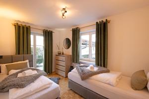 1 Schlafzimmer mit 2 Betten und einem Fenster in der Unterkunft 'Chalet-Style' ruhige & zentrale 3-Raum-Suite direkt am Kurpark in Oberstdorf