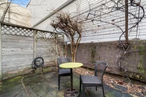 a table and chairs in a patio with a tree at Fairmount Neighborhood Gem in Philadelphia