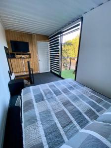 ein Schlafzimmer mit einem Bett und einem großen Fenster in der Unterkunft Krukke Valdivia in Valdivia