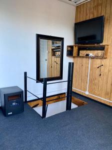 ein Wohnzimmer mit einem TV und einem Spiegel in der Unterkunft Krukke Valdivia in Valdivia