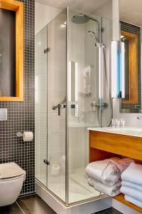 Focus Hotel Premium Sopot في سوبوت: حمام مع دش ومرحاض ومغسلة