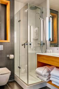 łazienka z prysznicem, toaletą i umywalką w obiekcie Focus Hotel Premium Sopot w mieście Sopot