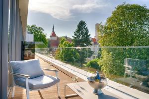 a chair on a balcony with a view of a city at Focus Hotel Premium Sopot in Sopot